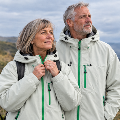 Brecon Shell Jacket in Mist Grey – woman zipping up the jacket