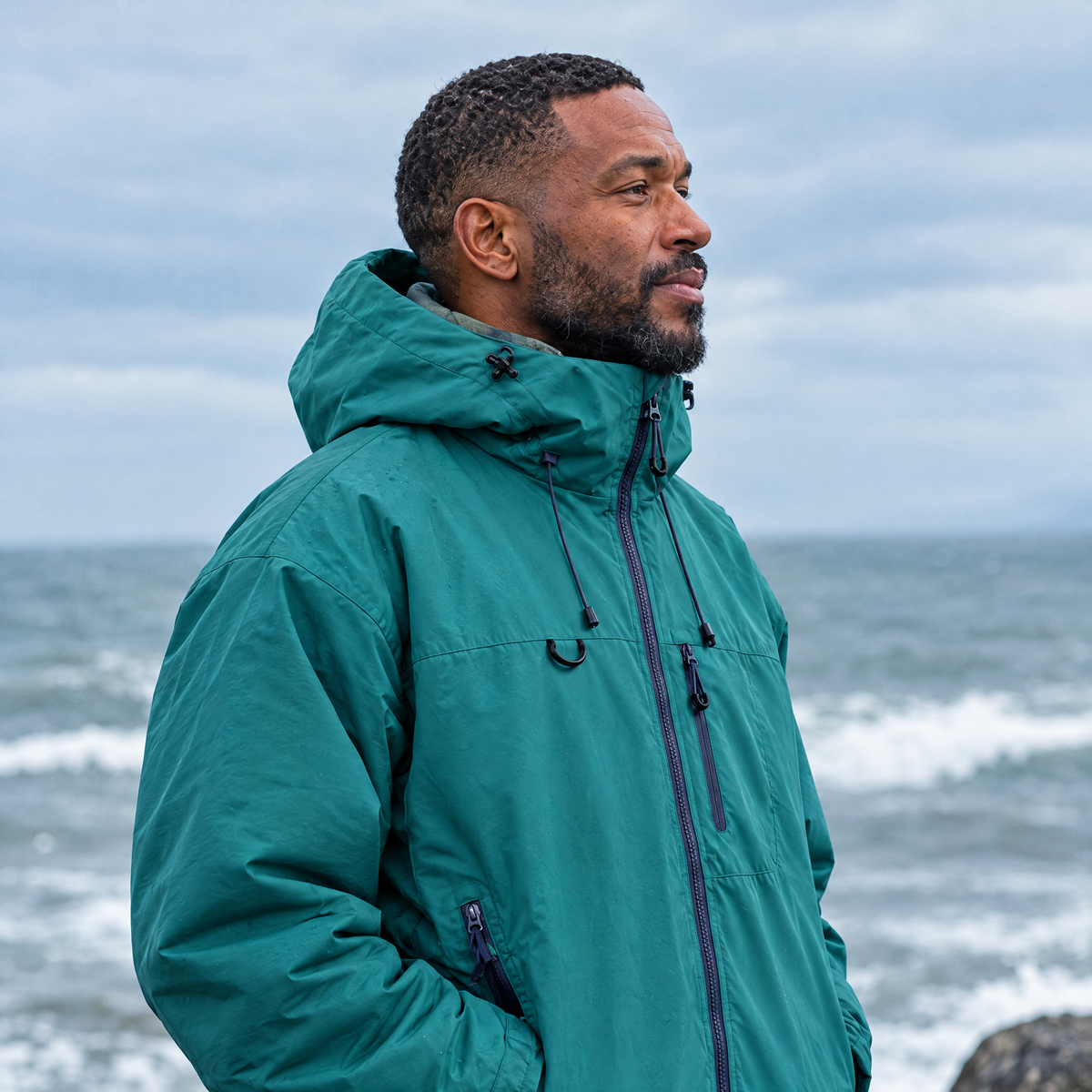 Brecon Shell Jacket in Deep Teal – man on the seafront