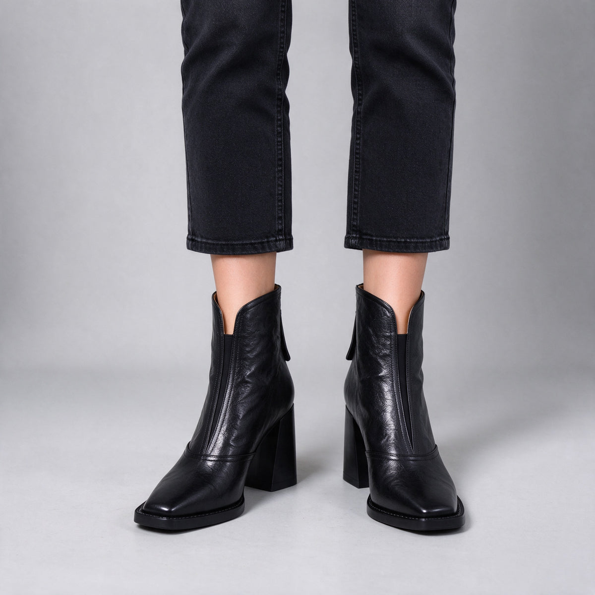 Livia black leather ankle boots on foot, front view