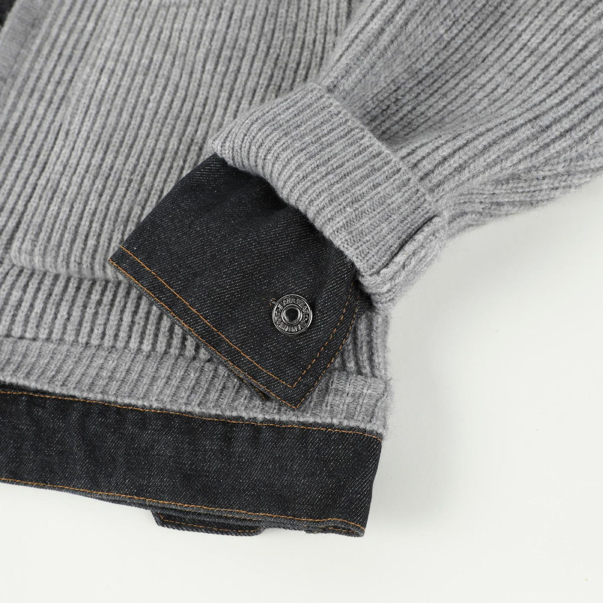 Denim cuff tab with metal button on the sleeve